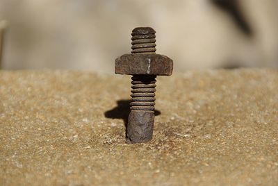 Close-up of rusty nut in concrete