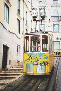 Cable car on street against building in city