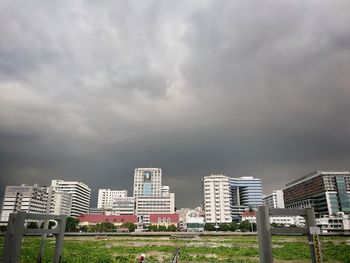 View of cityscape against cloudy sky