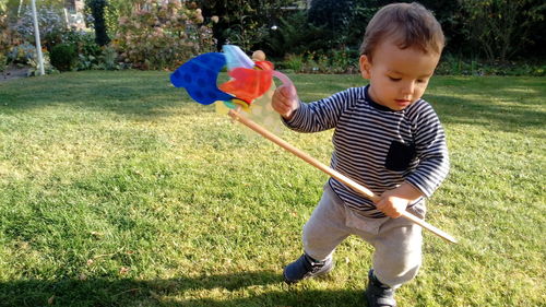 Boy with umbrella standing on field