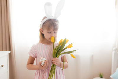 Full length of a girl holding white tulip