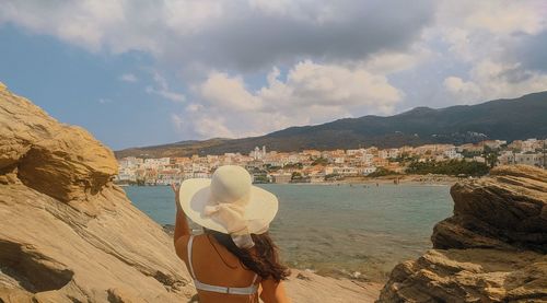 Rear view of woman looking at view of mountain against sky