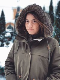 Portrait of young woman standing in snow