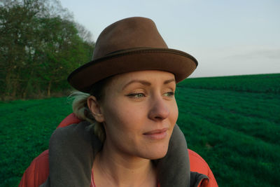 Close-up of young woman wearing hat on field