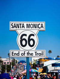 Information sign on road against clear blue sky