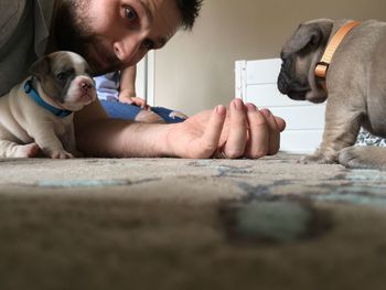 Portrait of man with puppy at home