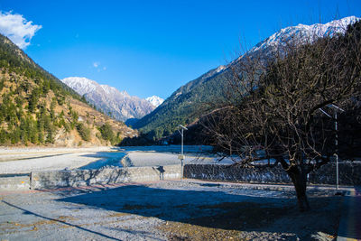 Scenic view of lake and mountains against blue sky