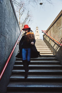 Rear view of woman walking on staircase