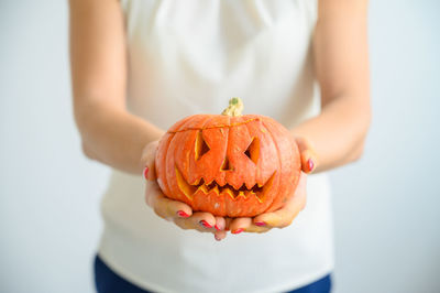Close-up of hand holding pumpkin during halloween