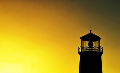 Low angle view of silhouette lighthouse against sky during sunset