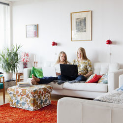 Teenage girls on sofa using laptop