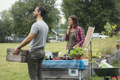 Mid adult couple selling vegetables at community garden