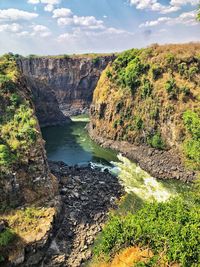 Scenic view of waterfall against sky