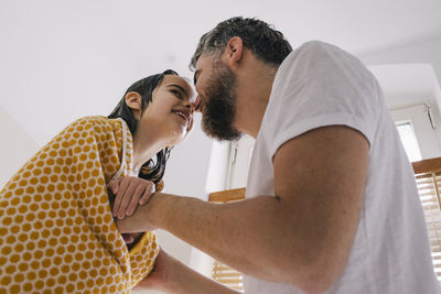 Smiling father and daughter rubbing noses in bathroom at home