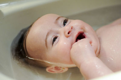 Close-up of cute baby boy in bathtub at bathroom