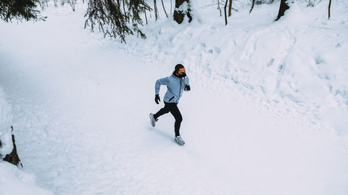 Man running on snow covered field