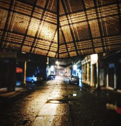 Brown umbrella next to road at night