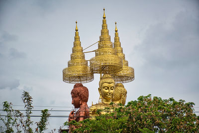 Low angle view of statue against temple building against sky