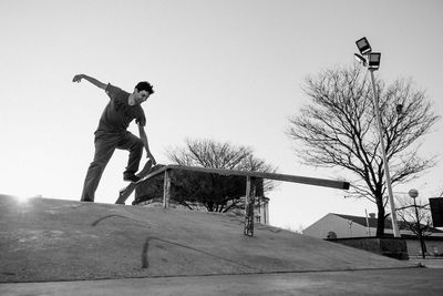 Skateboarder sliding black and white outdoors portrait