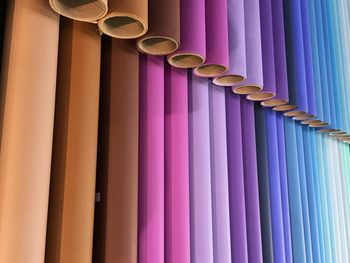 Full frame shot of colorful fabrics rolled around cardboard at store