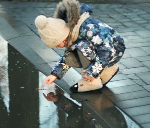 High angle view of woman holding umbrella on street in city