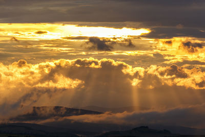 Scenic mountain landscape with sunbeams at dusk