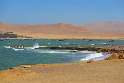 Pacific coast with many fishing boats view from paracas national reserve, ica region of peru