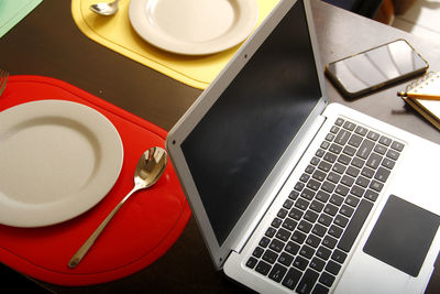 High angle view of coffee and laptop on table