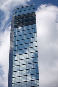 Low angle view of modern building against cloudy sky