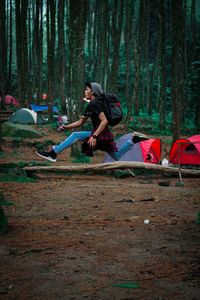 Side view of young man cycling in forest