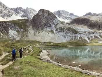 Rear view of people on rocks against mountains