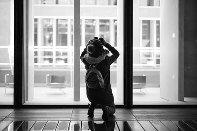 Woman standing by window at home
