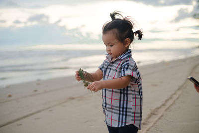 Boy holding umbrella on beach
