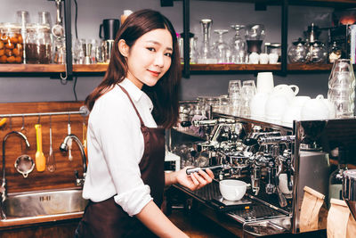 Portrait of smiling woman standing in restaurant