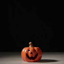 Close-up of pumpkin on table against black background