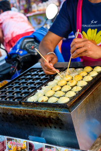 Low angle view of man preparing food at market stall