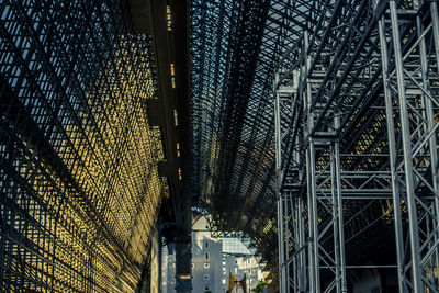 Low angle view of illuminated bridge against buildings in city