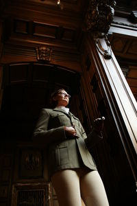 Low angle view of woman looking away while standing at entrance