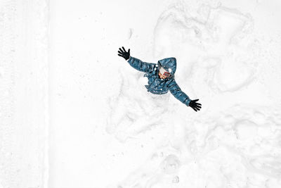 High angle view of happy woman standing in snow