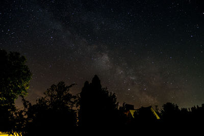 Low angle view of silhouette trees against sky at night