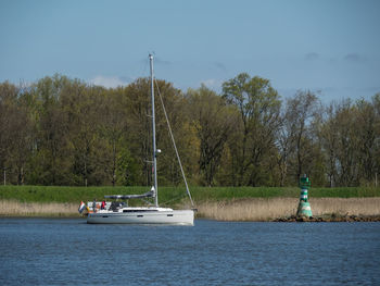 Sailboats sailing on lake against sky
