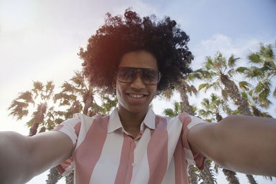 Young latin man takes a selfie photo on the smartphone camera. top view