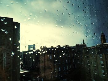 City buildings seen through wet glass window