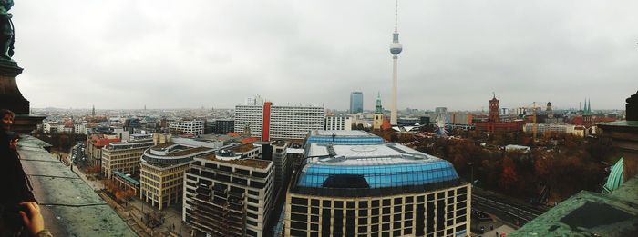 Buildings in city against cloudy sky