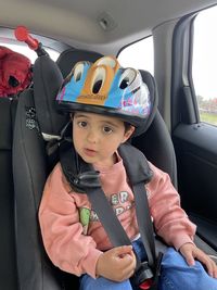 High angle view of cute girl sitting in car