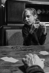 Portrait of a long haired boy sitting at table