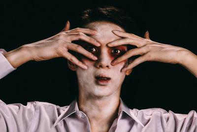 Close-up portrait of young man against black background