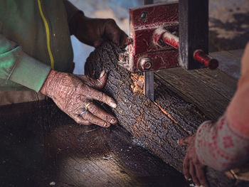 Cropped image of carpenters cutting wood