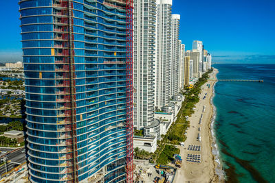 Panoramic view of beach and buildings against blue sky