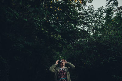 Woman standing on tree trunk